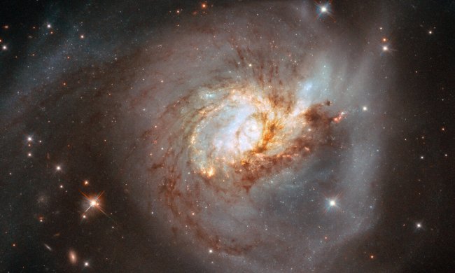 The peculiar galaxy NGC 3256 takes centre stage in this image from the NASA/ESA Hubble Space Telescope. This distorted galaxy is the wreckage of a head-on collision between two spiral galaxies which likely occurred 500 million years ago, and it is studded with clumps of young stars which were formed as gas and dust from the two galaxies collided.