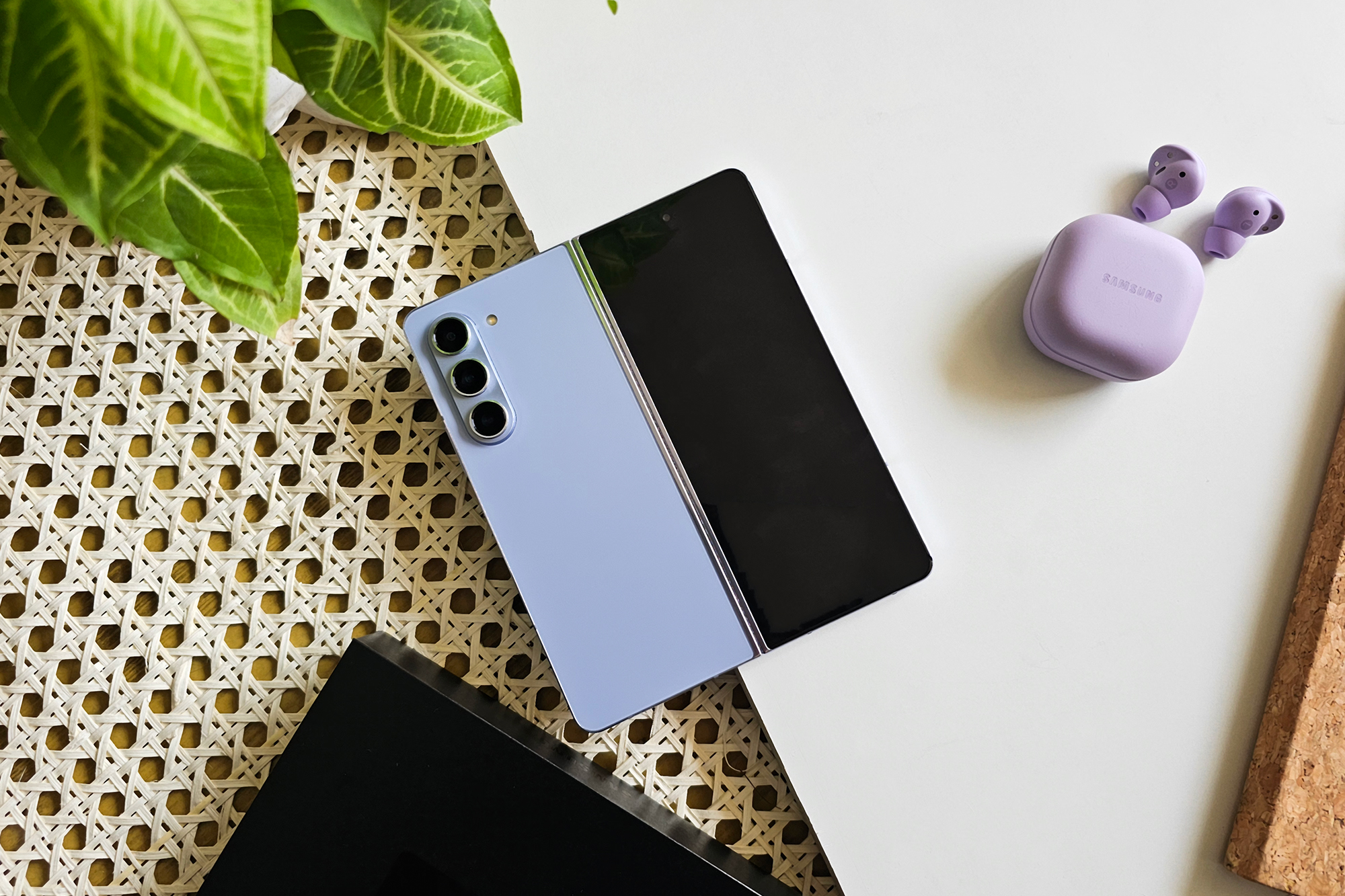 Samsung Galaxy Z Fold 5 on a flat surface with the purple Galaxy Buds 2 Pro TWS Bluetooth earbuds on the side.