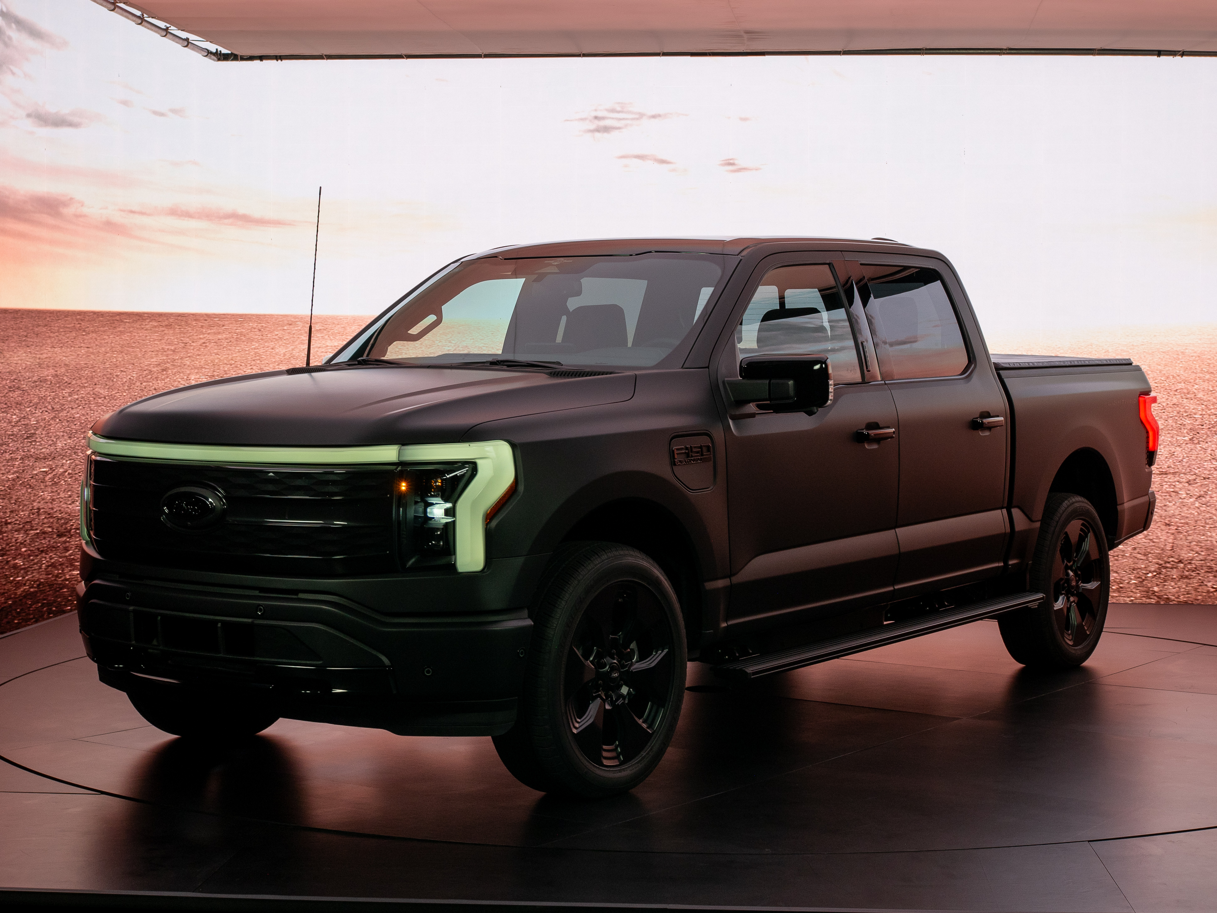 An F-150 Lightning Platinum Black model in dim lighting.