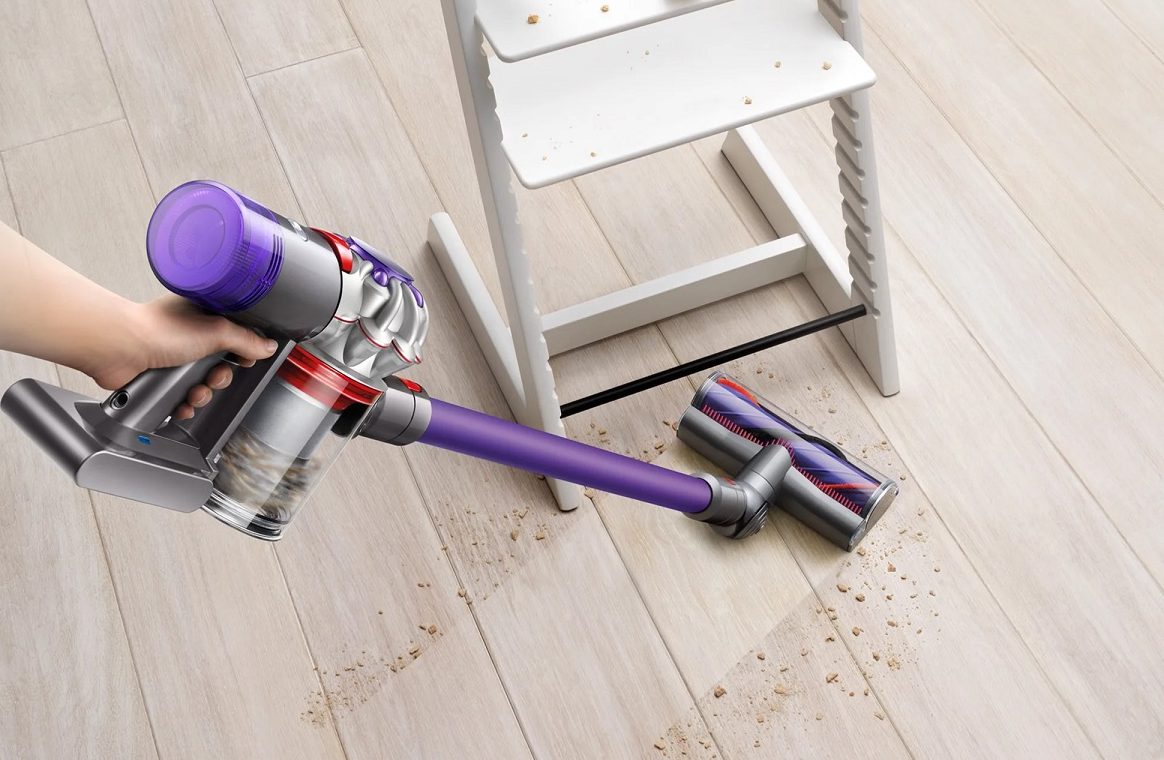 Someone using the Dyson V8 Origin Plus cordless vacuum.