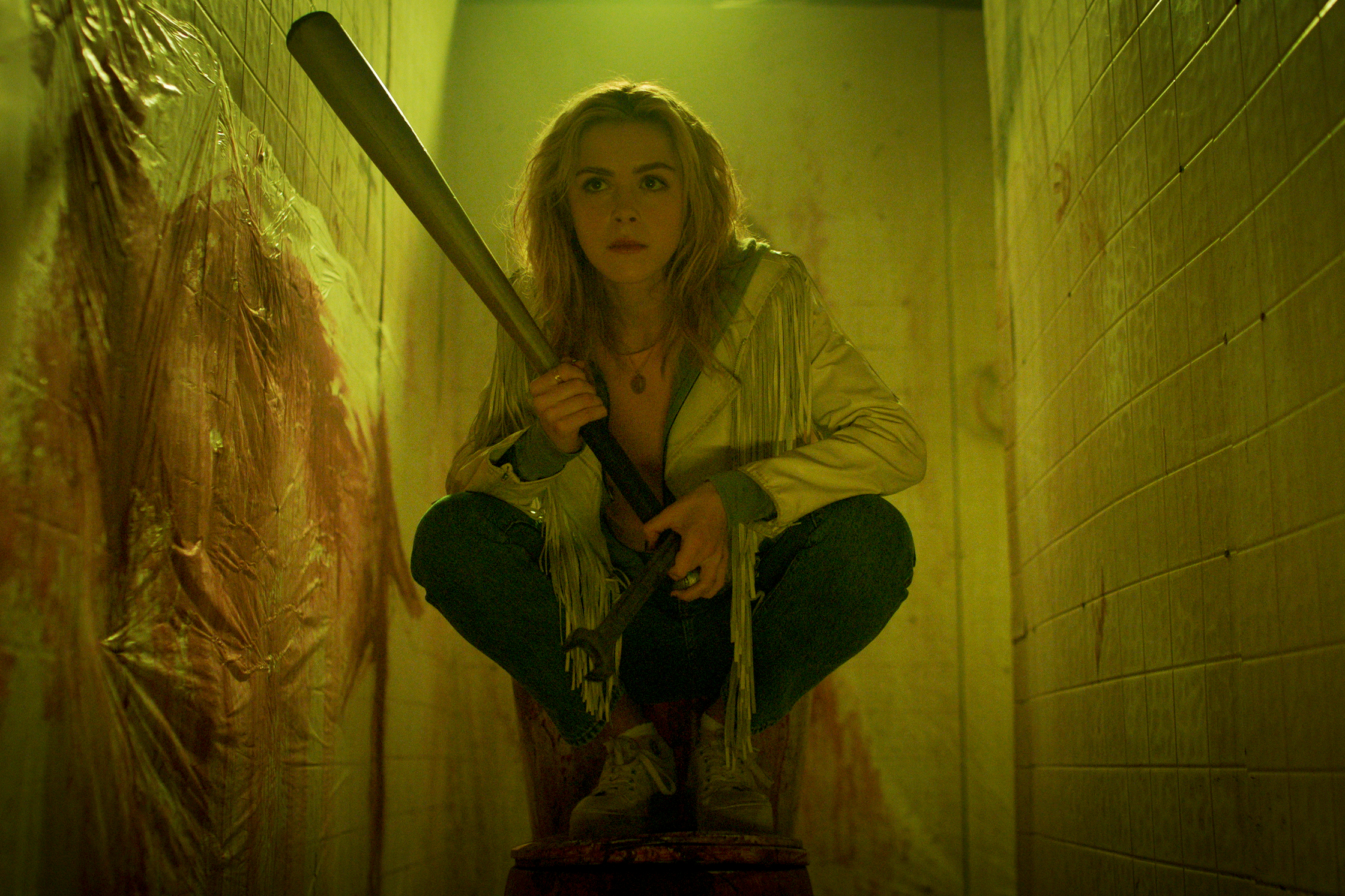 Kiernan Shipka crouches with a bat in Totally Killer.