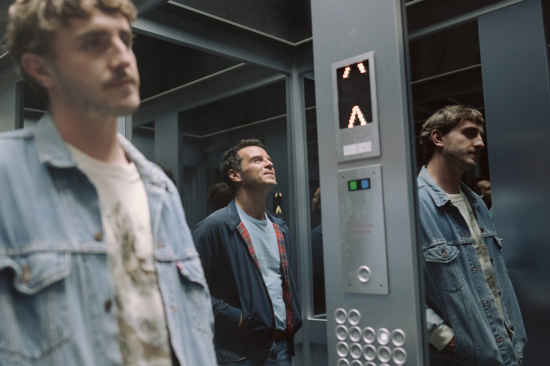 Two men ride an elevator in All of Us Strangers.