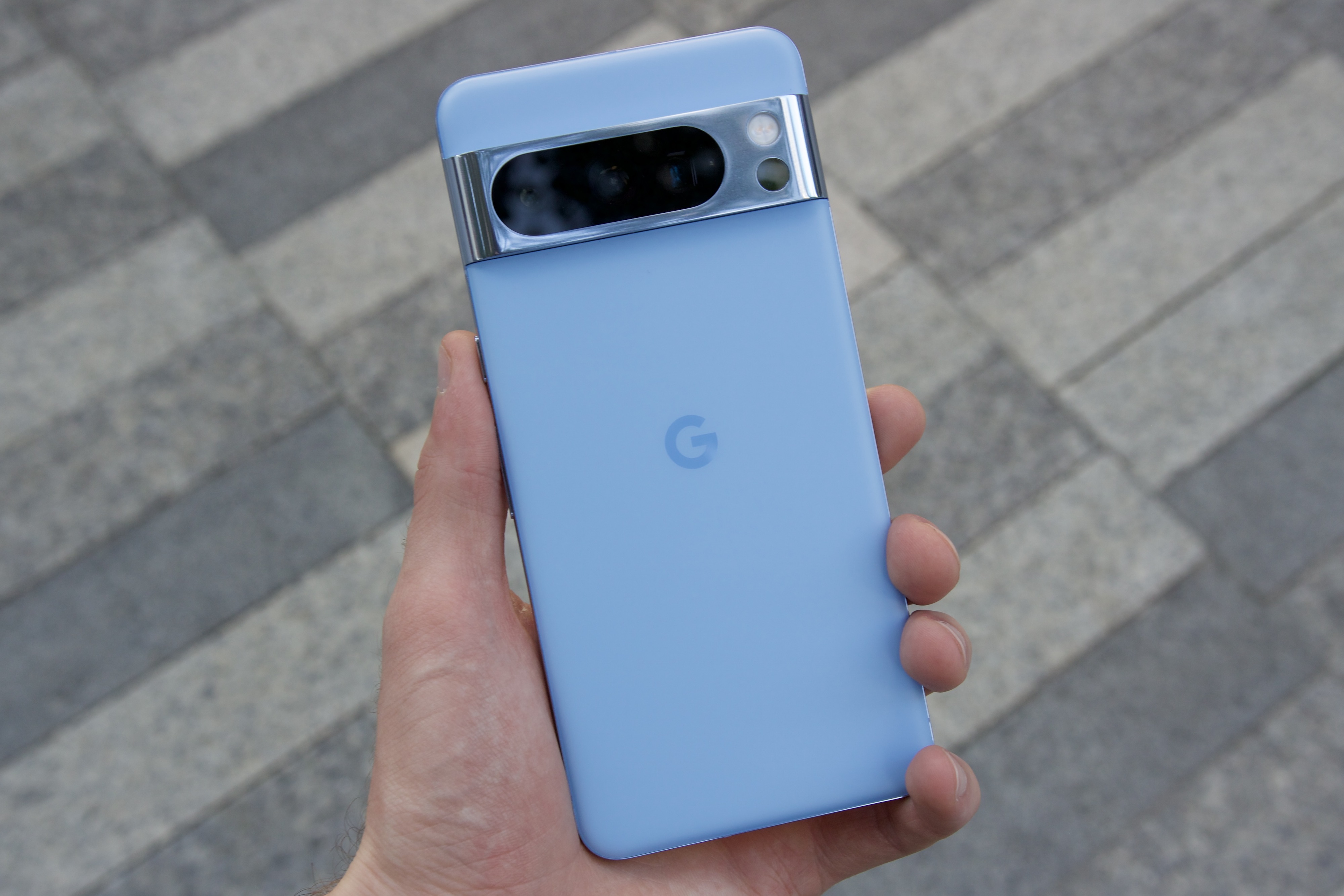 Someone holding the Bay blue Google Pixel 8 Pro.