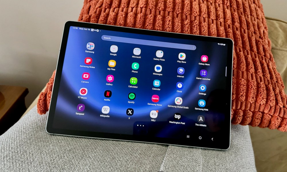 The Samsung Galaxy Tab S9 FE+ laying on pillows.