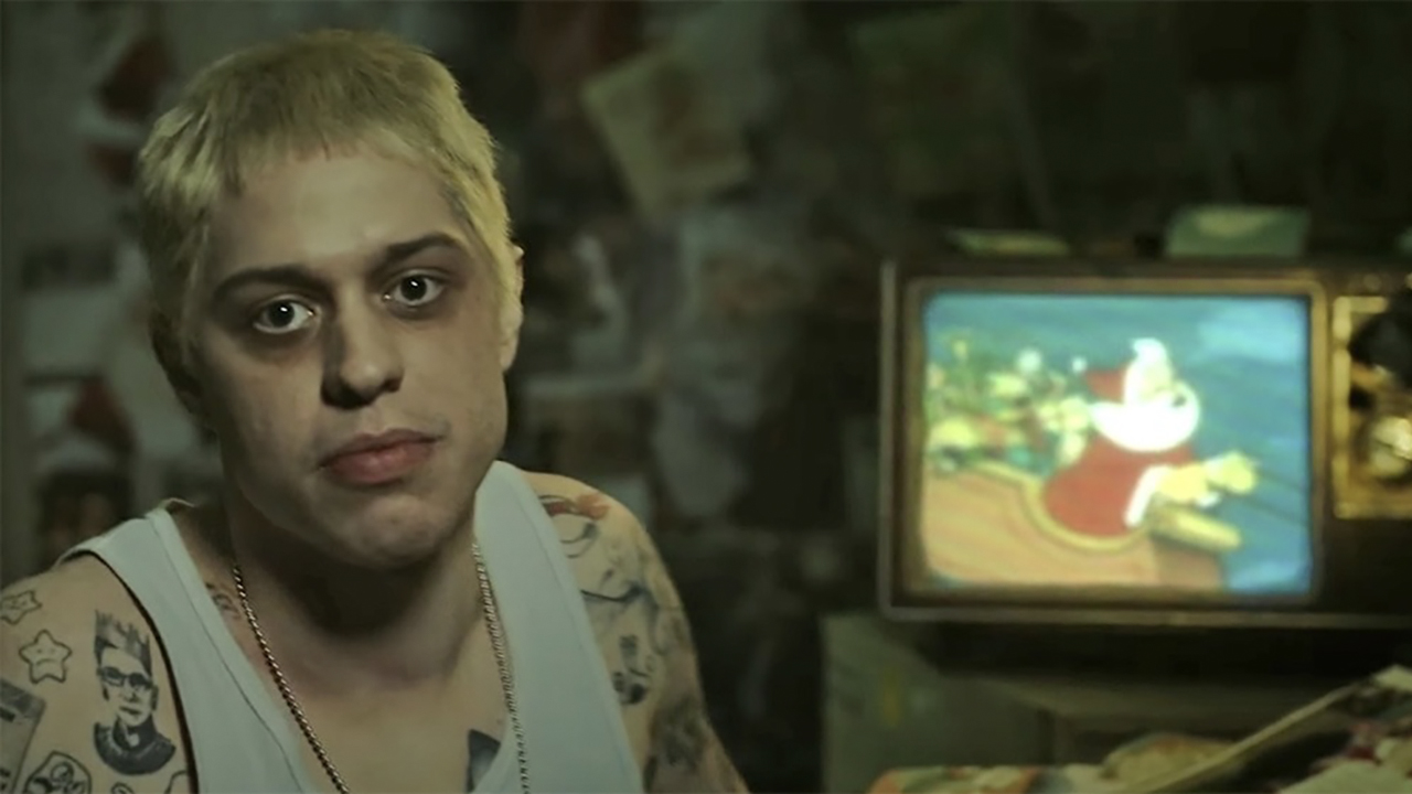 Pete Davidson in a white tank and dark circles around his eyes playing the character Stu in the SNL Digital Short.