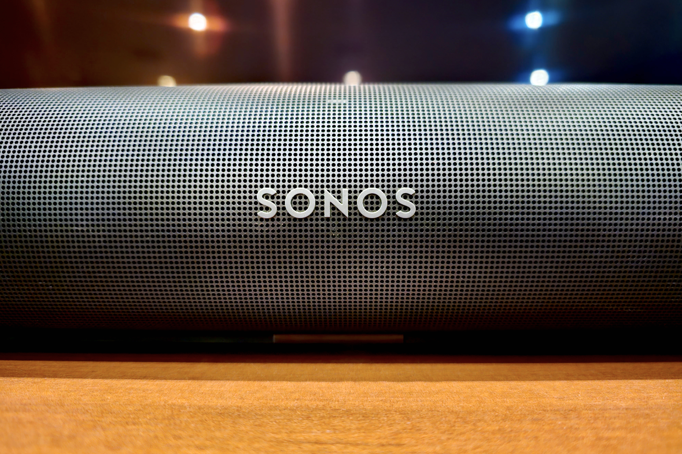 Close up of Sonos logo on a Sonos Arc soundbar.