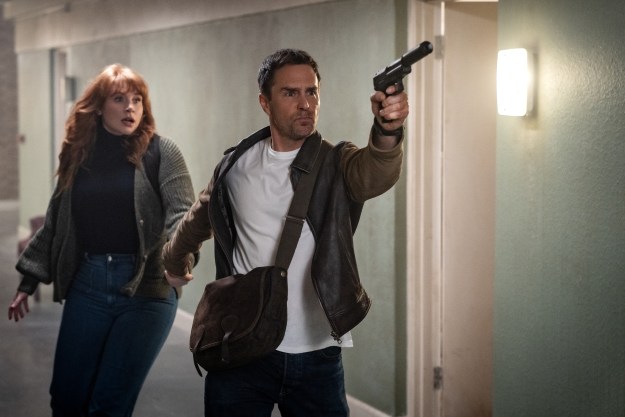 Bryce Dallas Howard stands behind a gun-wielding Sam Rockwell in Argylle.