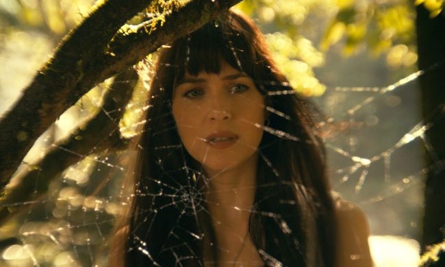 Dakota Johnson looks through a spiderweb in an image from Madame Web