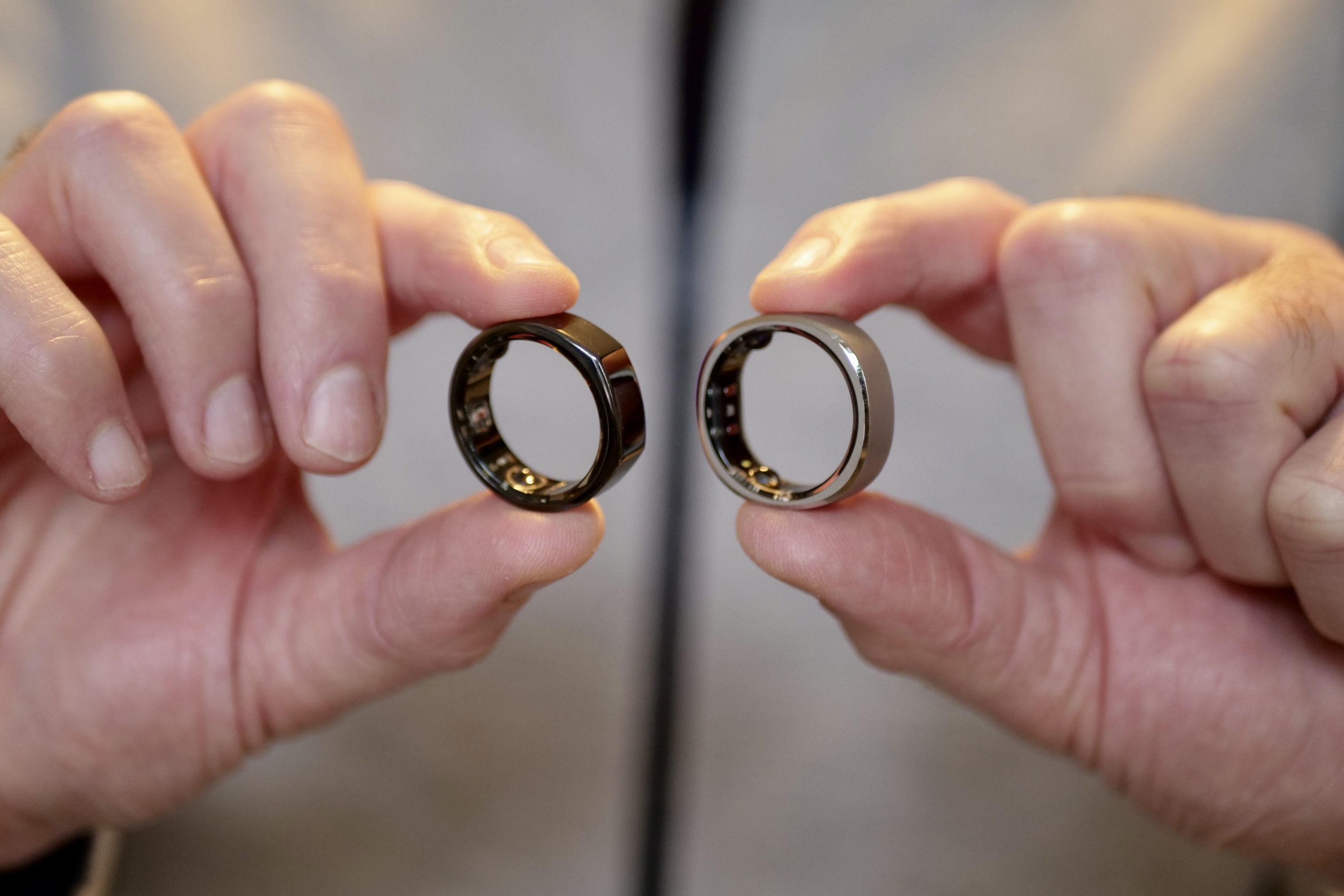 A person holding the RingConn Smart Ring and Oura Ring.