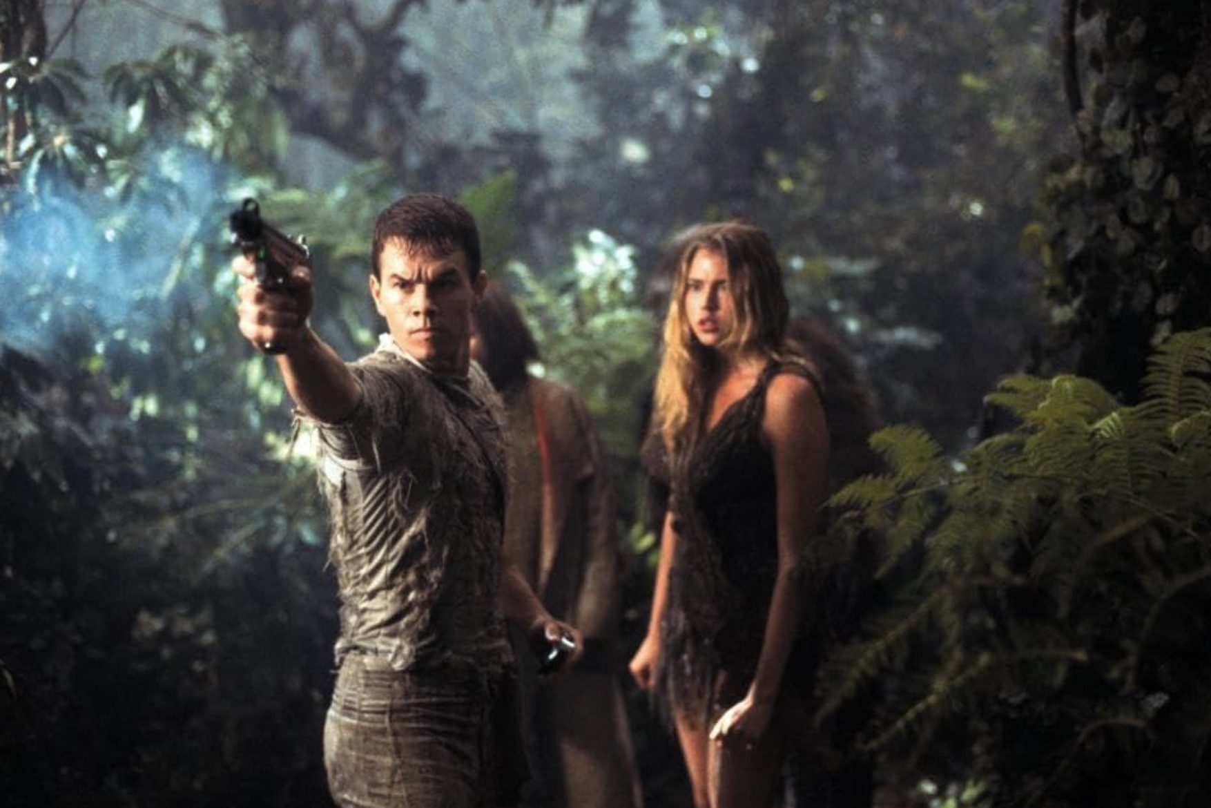 A man stands in front of a woman and points a gun.