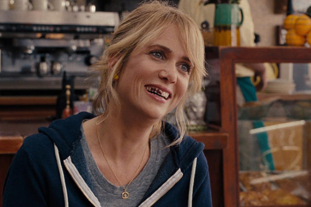 A woman smiles in Bridesmaids.