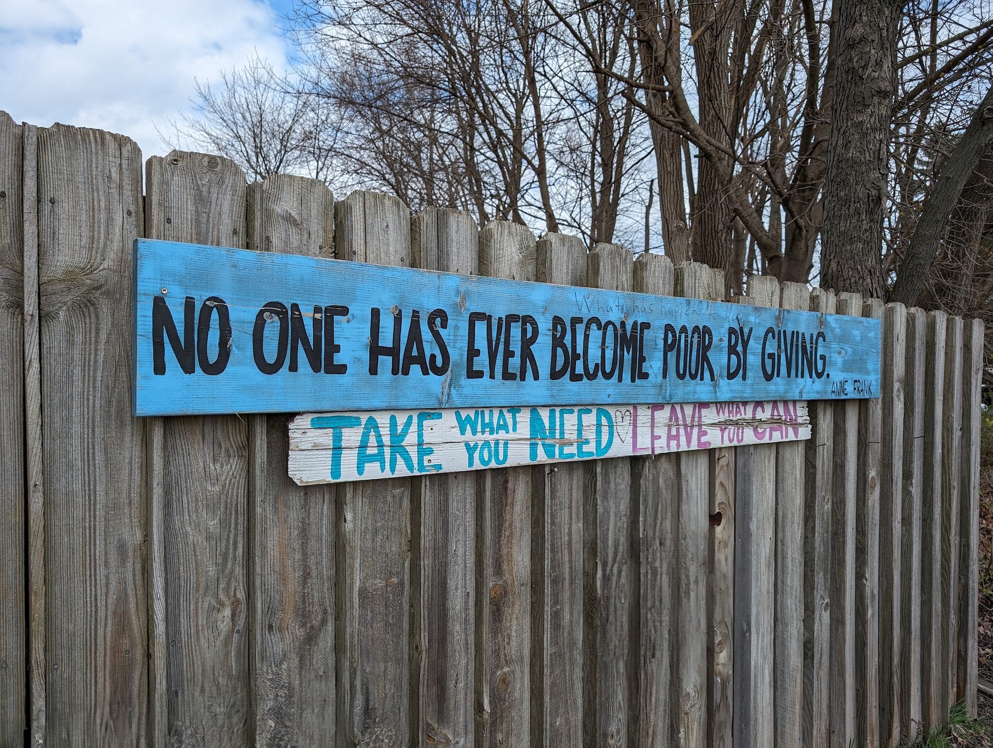 A photo of a blue sign on a fence, taken with the Google Pixel 8.