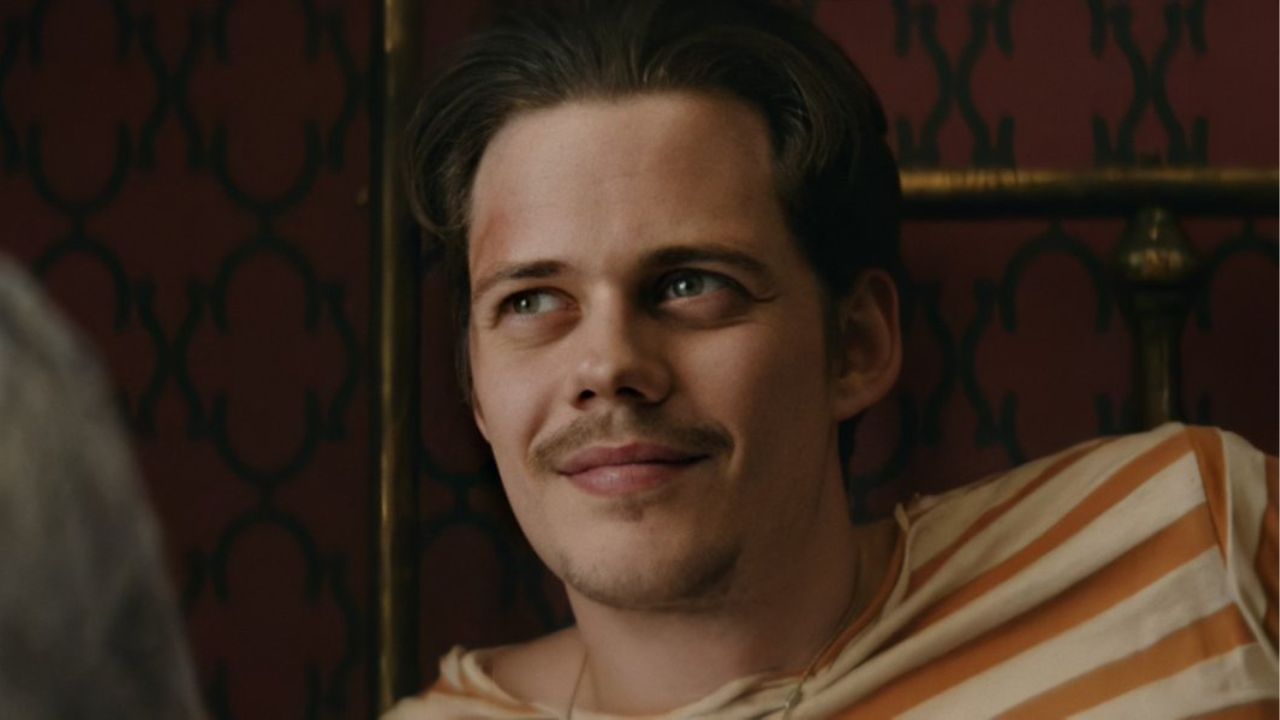 Bill Skarsgård as Mickey smiling at someone off-camera in Villains.