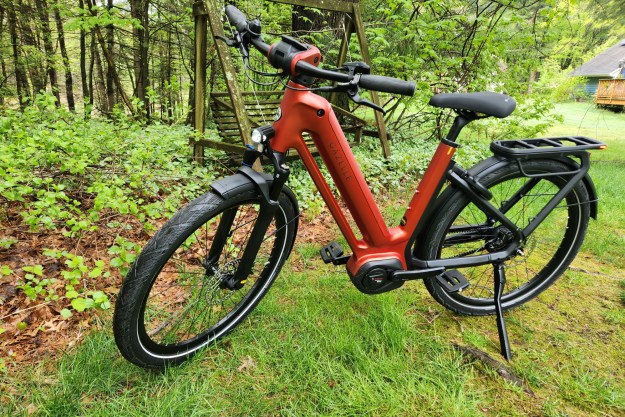 Gazelle Eclipse e-bike left profile view parked on grass with trees and an old swing in the background.