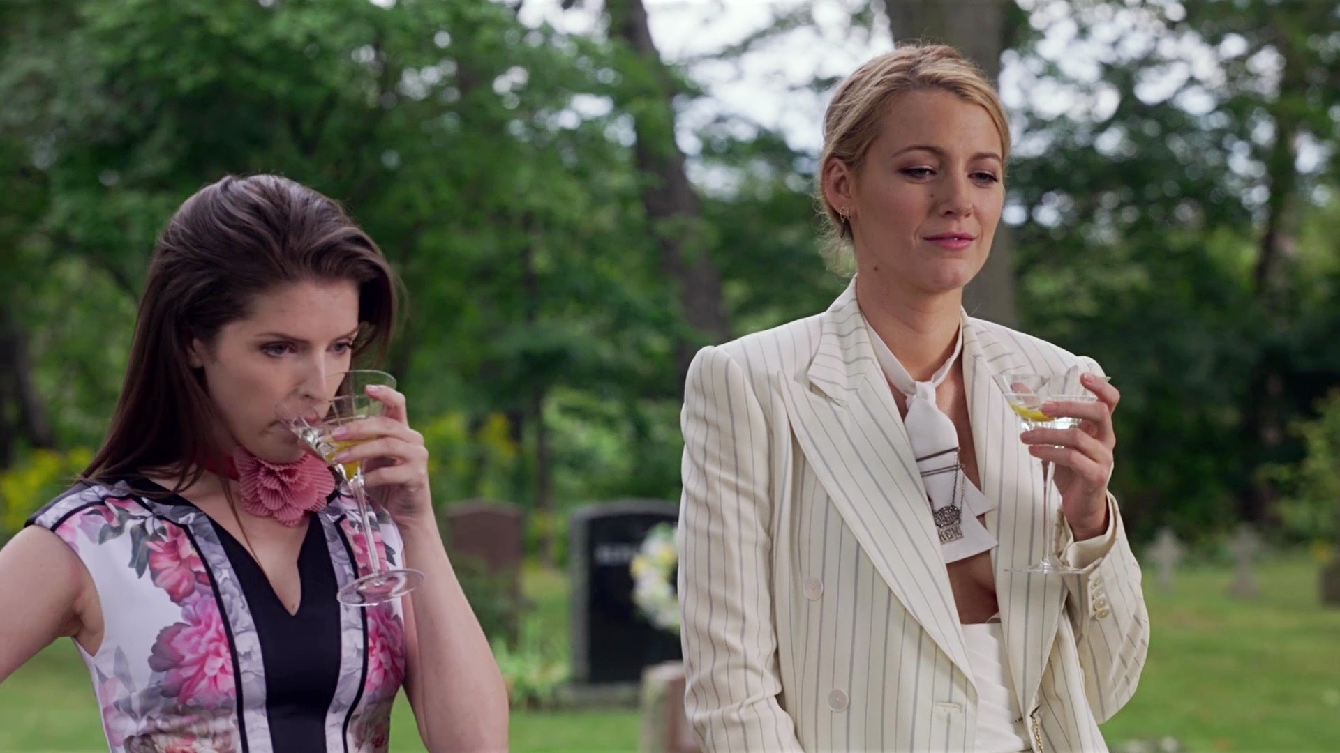 Anna Kendrick and Blake Lively as Stephanie and Emily drinking martinis in a graveyard in A Simple Favor.