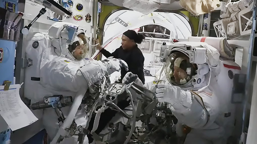 NASA astronaut Jeanette Epps (center) is pictured assisting NASA astronauts Mike Barratt (left) and Tracy C. Dyson (right) inside the Quest airlock. 