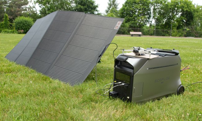 EcoFlow Delta Pro 3 power station on grass, connected to solar panels and several personal devices.