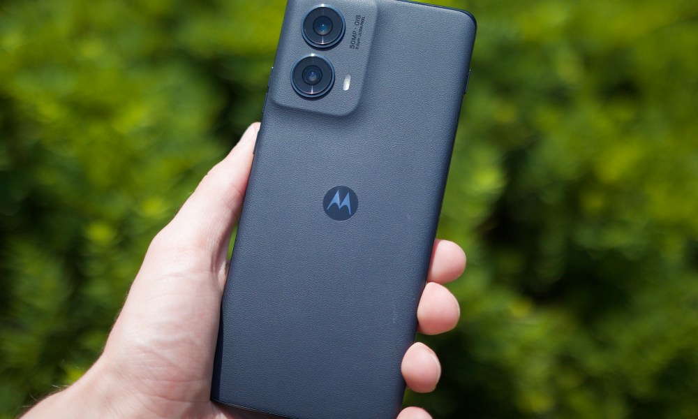 Someone holding the Motorola Edge (2024) outside, showing its leather back.