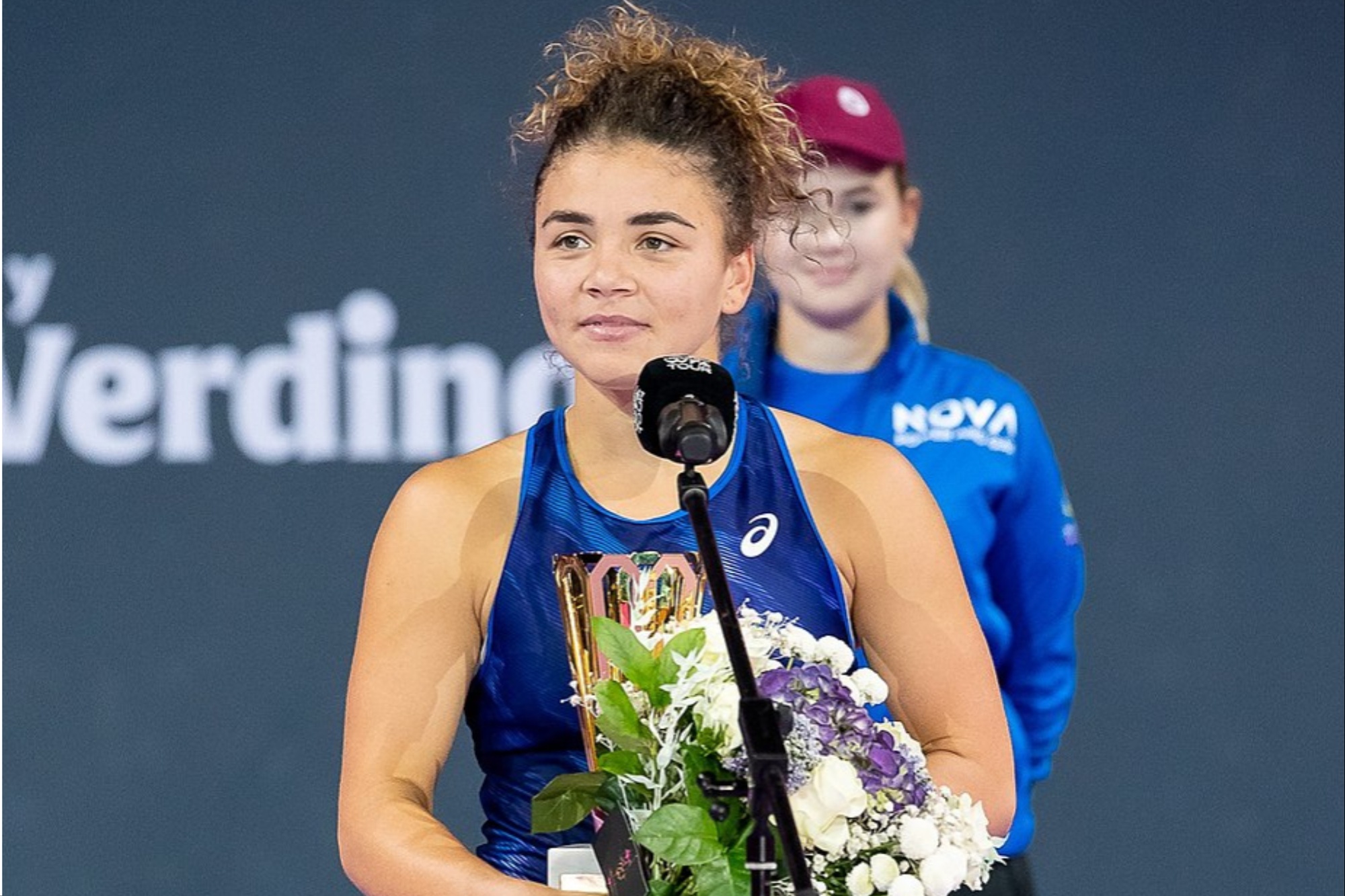 A woman poses for a photo with a trophy.