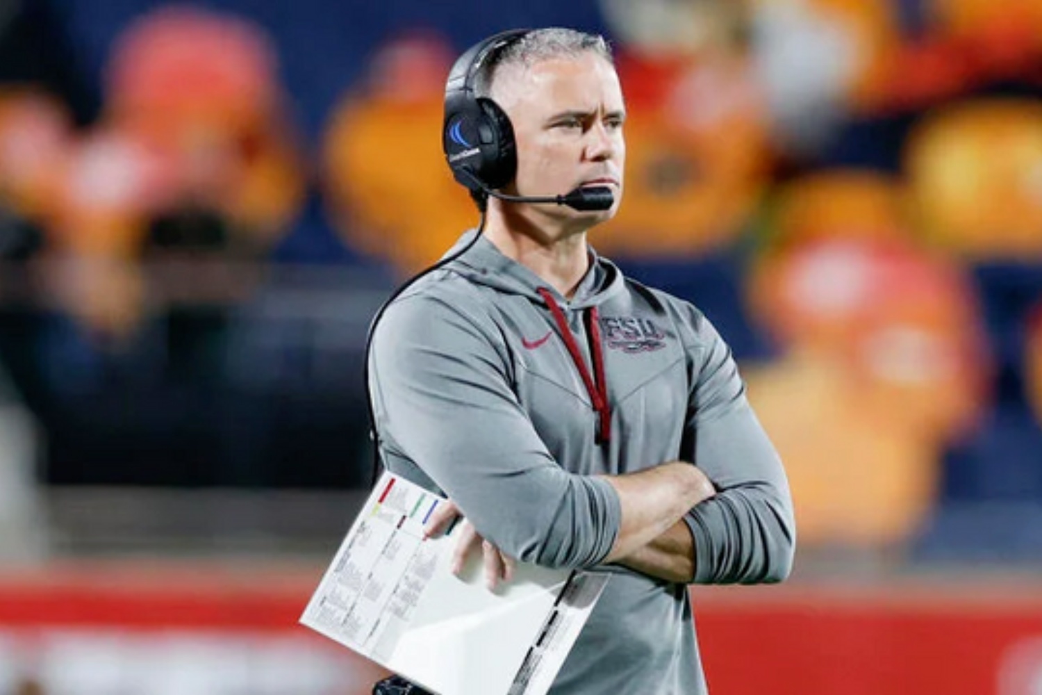 Mike Norvell stands on sidelines with his hands in his armpits.