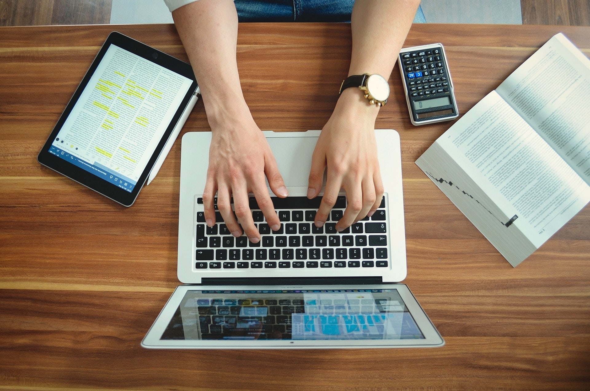 Student typing on a laptop at a desk.