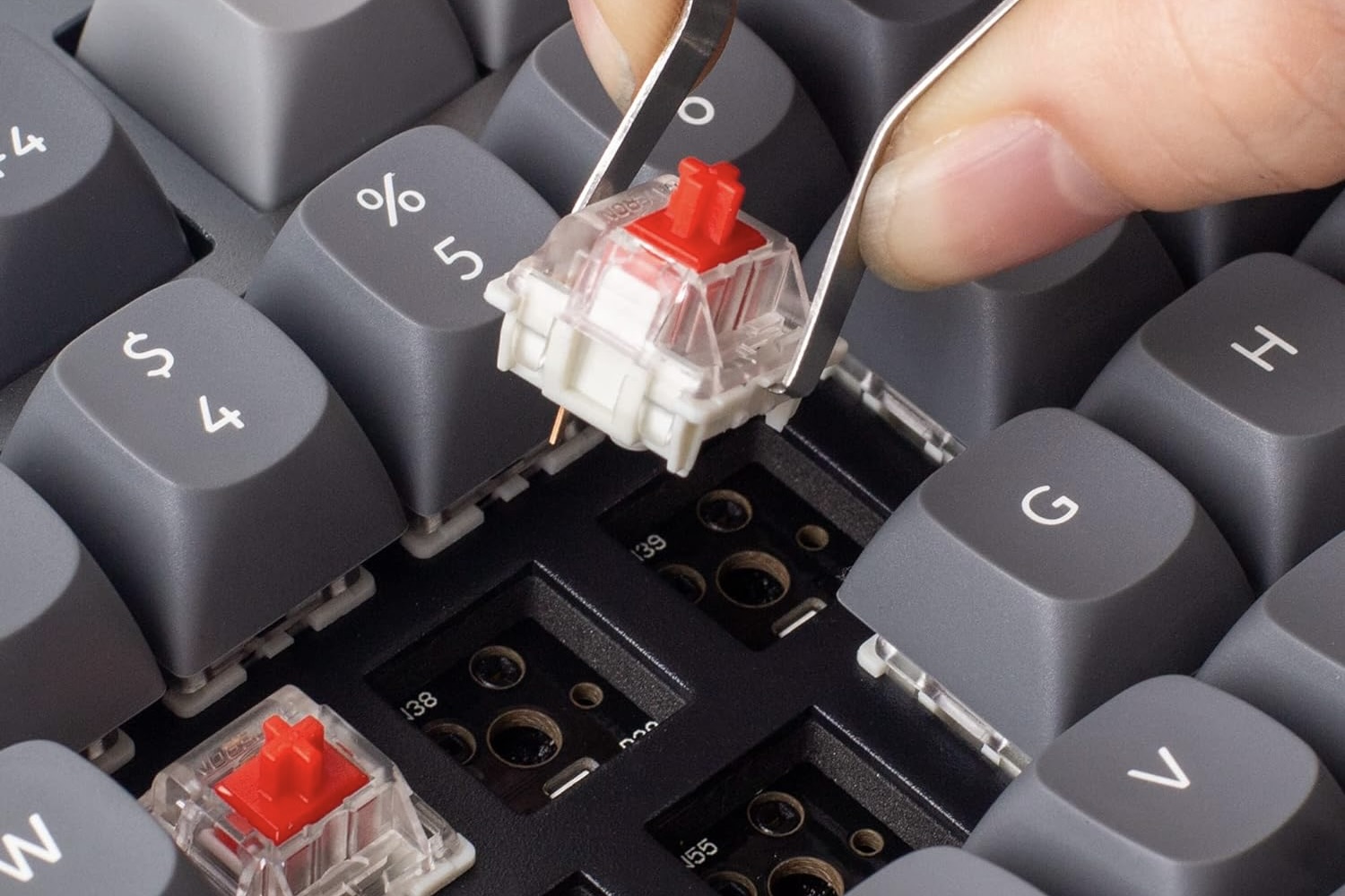 A person using tweezer to swap keys on the Keychron Q3 QMK/VIA Mechanical Keyboard.