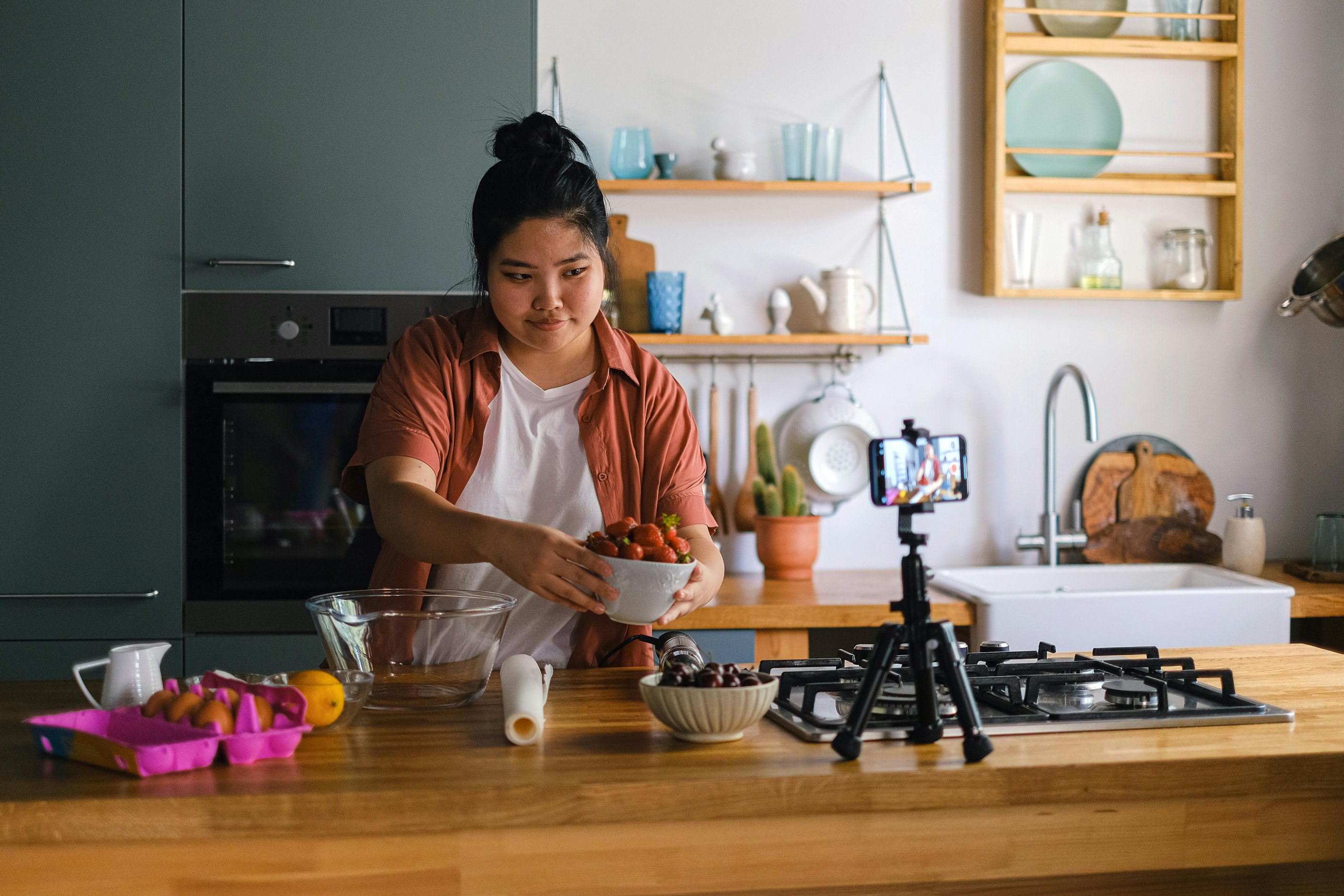 a content creator recording a thing in the kitchen with a bowl of food