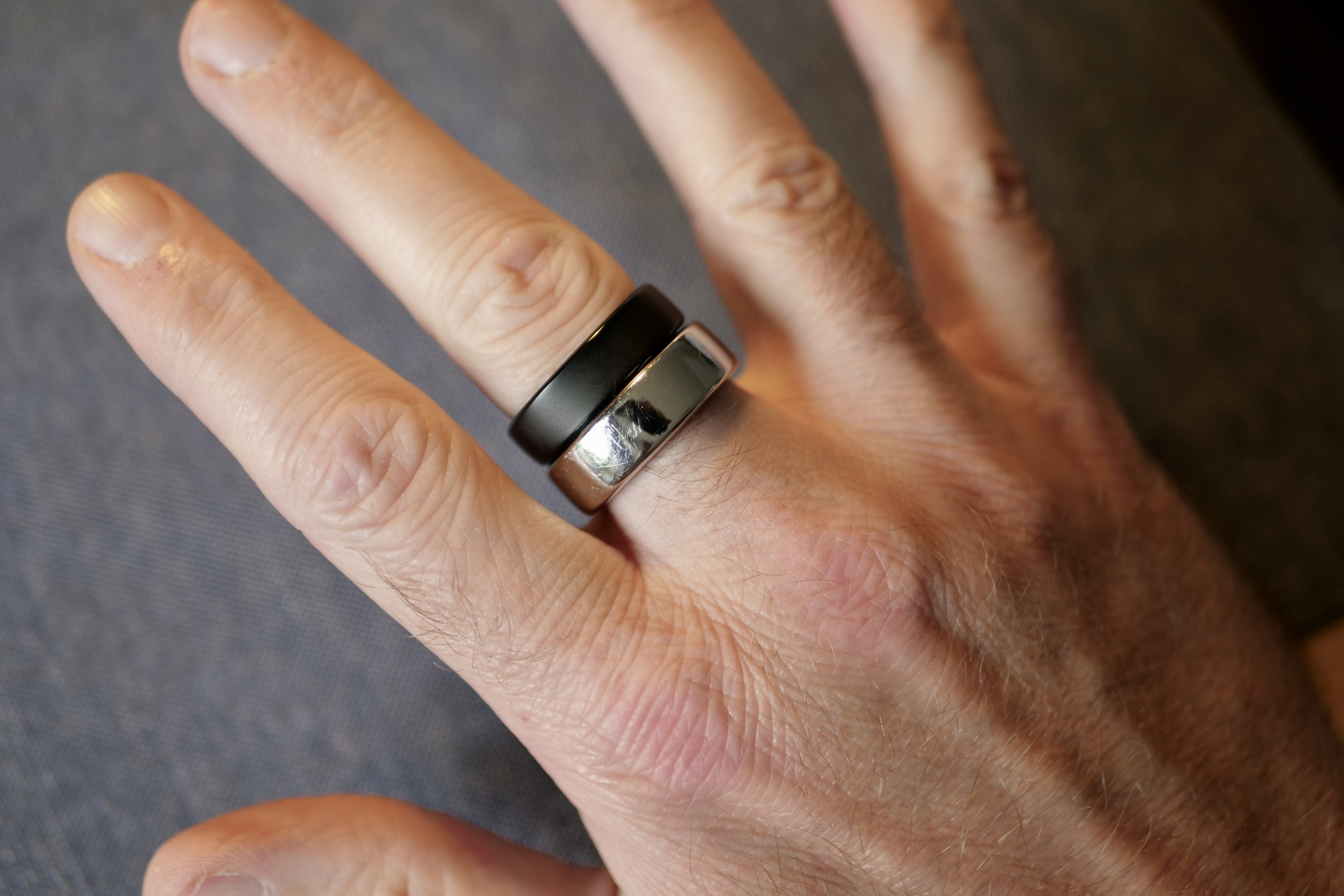 A person wearing the RingConn Gen 2 and Oura Ring smart ring.