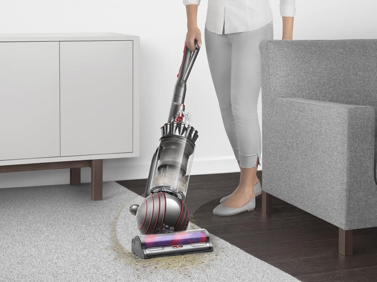 A woman vacuums with the Dyson Animal 3.