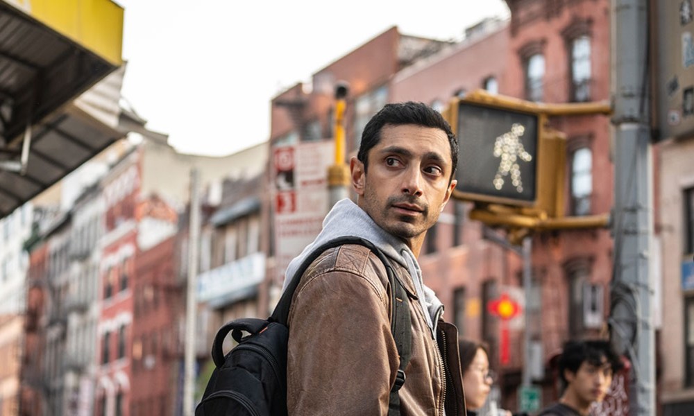 Riz Ahmed looks over his shoulder in a still from the movie Relay.