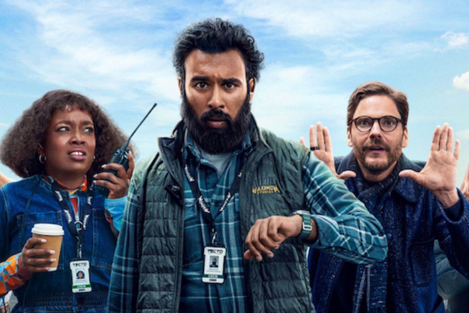 A man looks at his watch as a woman and another man stand behind him.