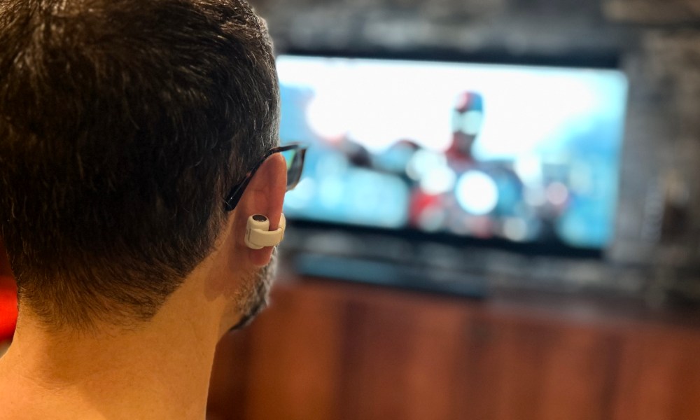 Simon Cohen wearing Bose Ultra Open Earbuds for Personal Surround Sound with a Bose Smart Soundbar.