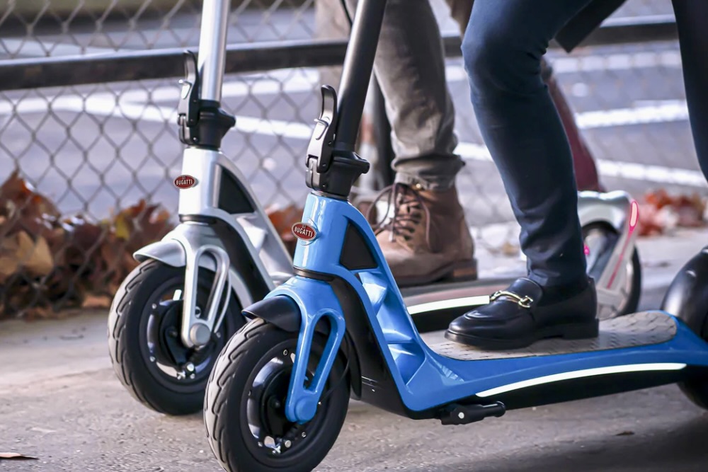 Two people using Bugatti 10.0 Max Electric Scooters.