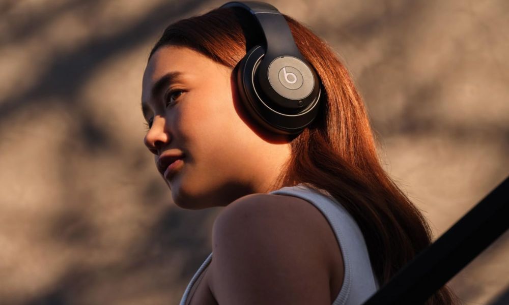 A woman wears Beats Studio Pro wireless headphones.