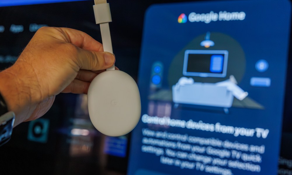 Chromecast with Google TV in front of a television showing the Google Home Panel.