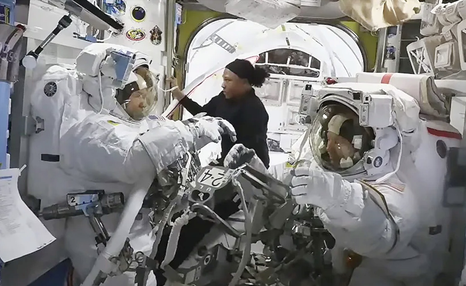 NASA astronaut Jeanette Epps (center) assists NASA astronauts Mike Barratt (left) and Tracy C. Dyson inside the Quest airlock.